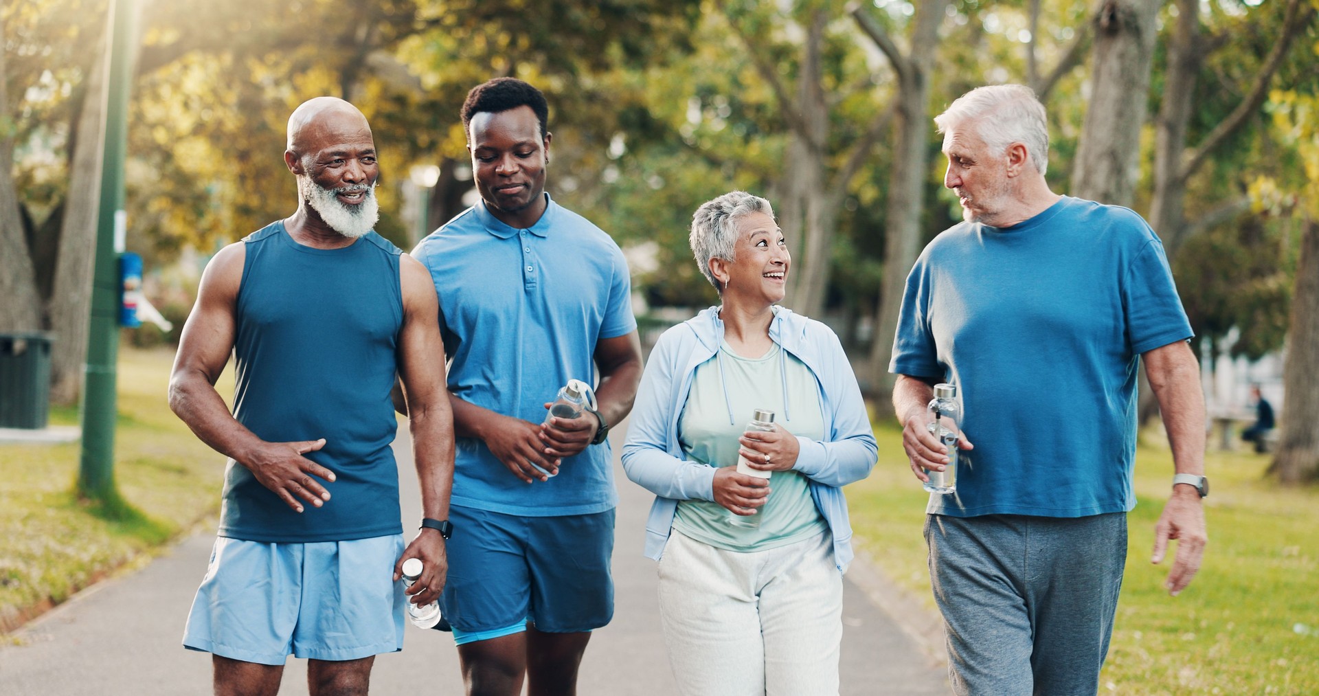 People, talking and walking for fitness outdoor with mobility training, discussion and morning routine. Senior, community and coach of conversation, exercise and motivation for cardio workout at park