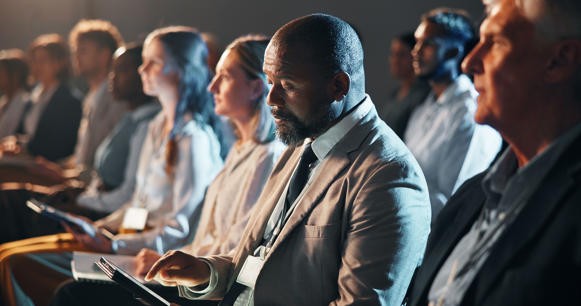 Tablet, audience and business people at conference, workshop or seminar for finance trading. Digital technology, crowd and male financial manager at fintech convention for training and networking.